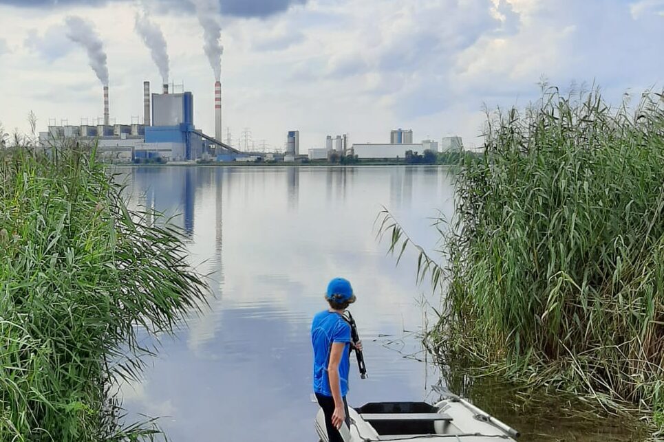 Am Gosławskie-See, einem der fünf beheizten polnischen Seen, nahmen die Forschenden zu verschiedenen Jahreszeiten Proben. Im Hintergrund ist das Kraftwerk Pątnów zu sehen, das warmes Wasser in die Seen einleitet.